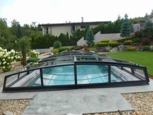 nízké zastřešení bazénu s konstrukcí v barvě antracit a průhlednou výplní