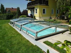 zastřešení bazénu s průhlednou výplní a konstrukcí stříbrný elox
